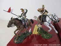 Two mounted Britains French lancer figures on horses displayed on top of boxes