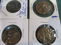 Four reproduction coins in cardboard flips