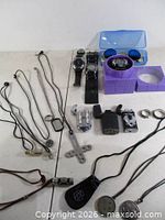 Lot overview showing watches, lighters, necklaces, rings, sunglasses