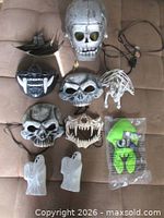 Group shot of all masks, skull, skeleton, ghosts, green figure