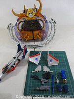 Unicron main body, planet ring pieces, Starscream fuselage and accessories laid out on cutting mat