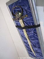 Full view of sword mounted on crushed-velvet board