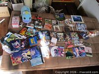 Full spread of games, prints, plush, figures and accessories on surface