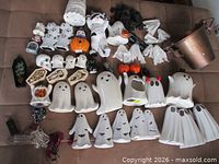 Full lot overview on couch: ceramic ghosts, coffins, cookie jar, pail, skulls, lights, webbing, pumpkins, shakers