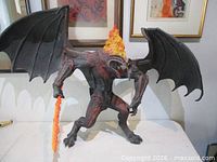 Front view of Balrog figure with wings extended holding flame sword