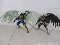 Front view of both action figures standing, wings extended