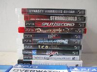 Stack of ten PS3 game cases showing spines with titles