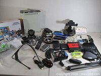 Overview of entire lot including Xbox 360, Logitech G13, handheld consoles, drone, headphones, mouse, microphone stand and accessories
