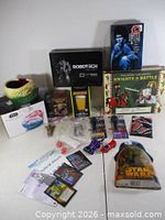 Group shot of all items including Jabba bowl, Robotech light, Pac-Man glass, DVDs, figures, dice and cards