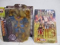 Front view of both unopened action figure packages: Marvel Select Thanos and Toy Biz Xena II