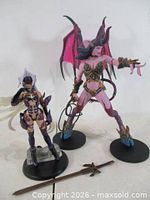 Both figures standing on bases with accessories visible