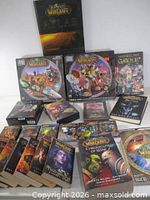 Group shot of atlas, two Mega-Bloks sets, DVD, novels, card packs