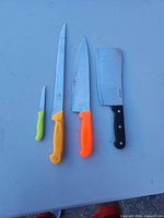 Front view of four knives aligned on table