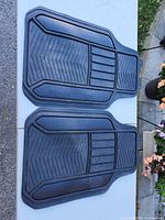 Two black front car floor mats side by side showing overall design
