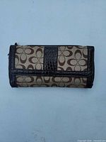 Front view of Coach signature canvas wallet with faux croc leather trim