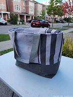 Full view of KeepCool striped insulated tote standing on table
