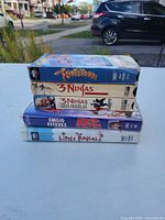 Five VHS tapes stacked showing spine titles