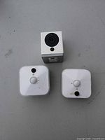 Front view of Wyze Cam v2 cube and two Blink square cameras