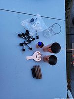 All items laid out: shaker tins, jigger, strainer, bar spoon, mixing glass, pour spouts, wooden blocks, cocktail pick