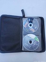Binder open showing two Xbox 360 discs including Halo: Reach