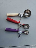 All three dishers side by side showing size and handle colours