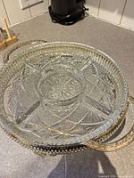 Crystal divided dish seated in silver-plated stand showing cut pattern and handles