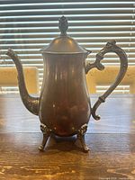 Full left profile of footed silver-plated teapot