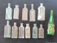 Overhead view showing all twelve antique bottles on black background