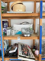Shelf view showing bamboo steamer, oven rack packaging, jars, grill accessories
