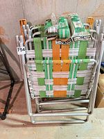 stacked view of four aluminum folding chairs with woven webbing and replacement webbing packs