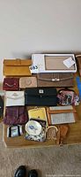 Group shot of all wallets, clutches and purses laid out on table