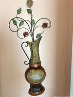 Full view of metal wall decor vase with flowers showing size, colors and design