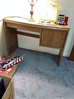 Full view of oak laminate desk showing drawer and cabinet door