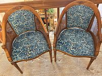 Pair of vintage wooden armchairs with caned sides, blue patterned upholstery, front view