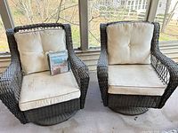 Front view of both wicker swivel chairs with cushions and packaged storage bag