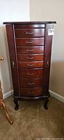 Front view of closed armoire showing seven drawers, dark mahogany finish, cabriole legs