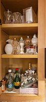 Cabinet view showing multiple glass shakers, shell napkin holders, boxed chef spreaders and novelty bottle shakers