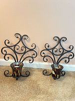 Pair of wrought iron scroll wall sconces with mosaic glass votive cups displayed front view