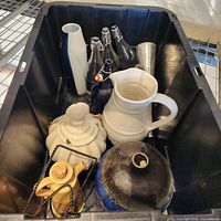 Overview of tote showing assorted ceramic vessels, cobalt bottles, metal tumbler