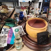 Mixed items overview showing planter, wooden trays, green pitcher, Dew bottle, plastic cases, wallet, photos