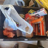 Overview of tote showing Lionel boxes, plastic bag, miscellaneous contents