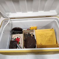 Open cooler showing film canister, reels, tins, envelope, flashlight