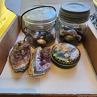 Overview of geodes, jars, tin, figurines in box
