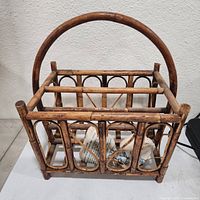 Front view of bamboo magazine basket showing handle and side design