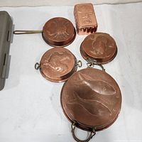 Group view of six copper molds including rectangular and round designs