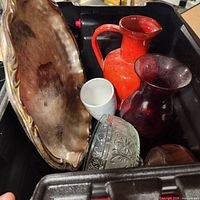 Bin showing metal tray, red pitcher, dark red vase, clear glass bowl, white mug