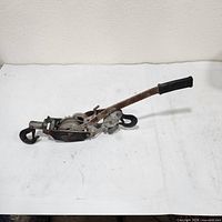 Side view of complete hand winch puller showing hooks, cable and handle