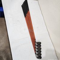 Full set of seven irons laid out head-to-toe