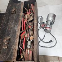 Toolbox with lid open showing contents and paint sprayer beside