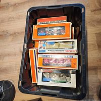Bin containing multiple Lionel boxed cars and accessories